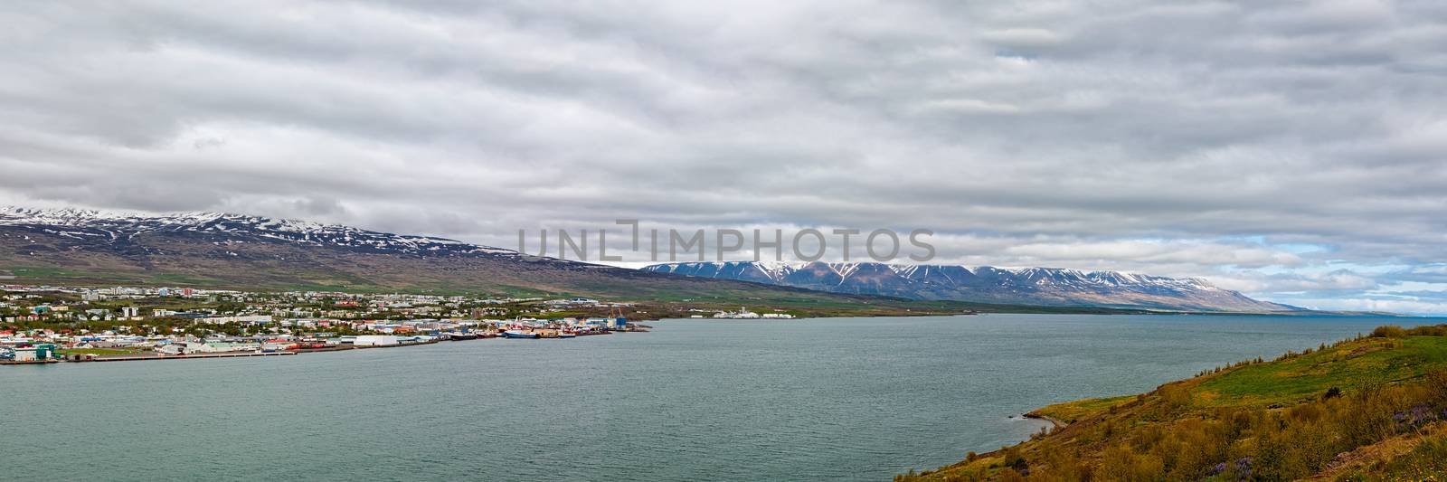 Panoramic view of Akureyri and mountains on background under a cloudy sky, Iceland