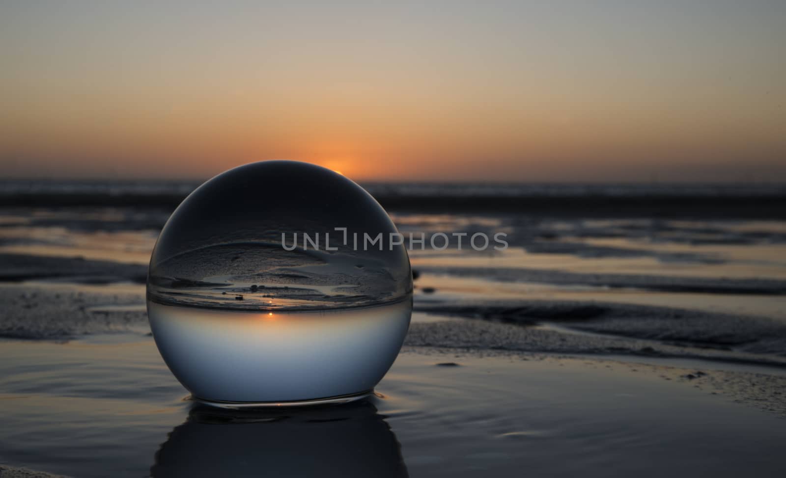 sunset on the beach captured in glass crystal sphere