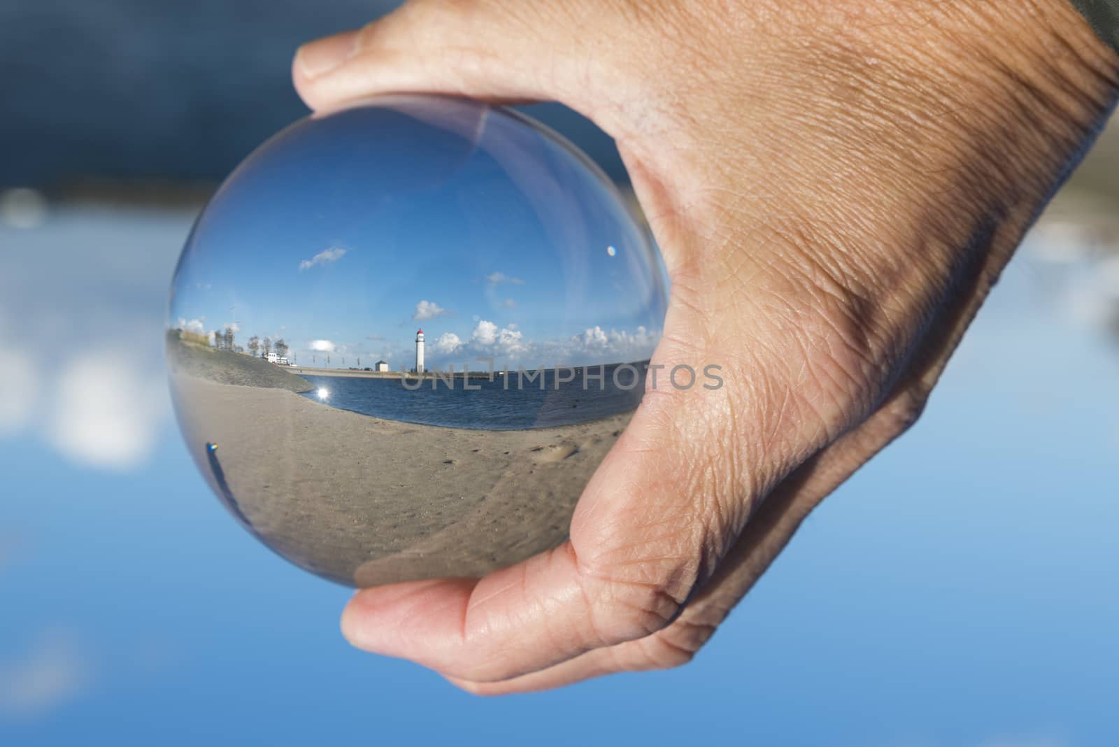 glass sphere with hellevoetsluis lighthouse from the beach