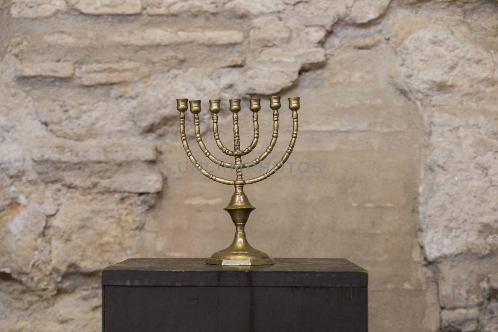 old religious menorah with ancient wall
