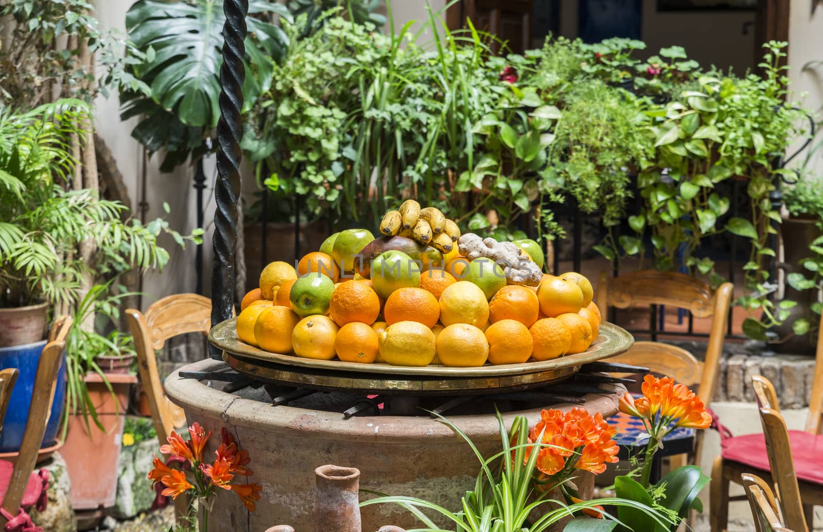 table with table with fresh fruit like oranges and bananas with table and chairs around