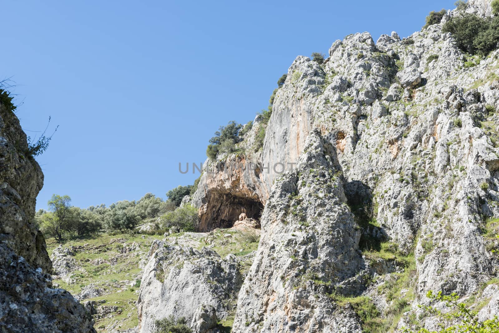 rocks with caves and blue sky in andalusia by compuinfoto