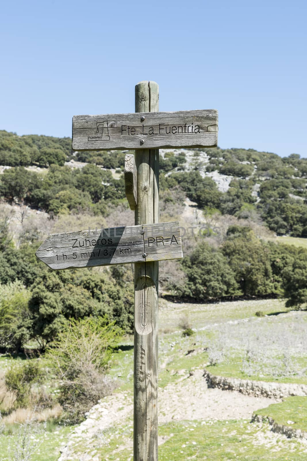 wooden pole with destination Zuheros and fountain la fuentria