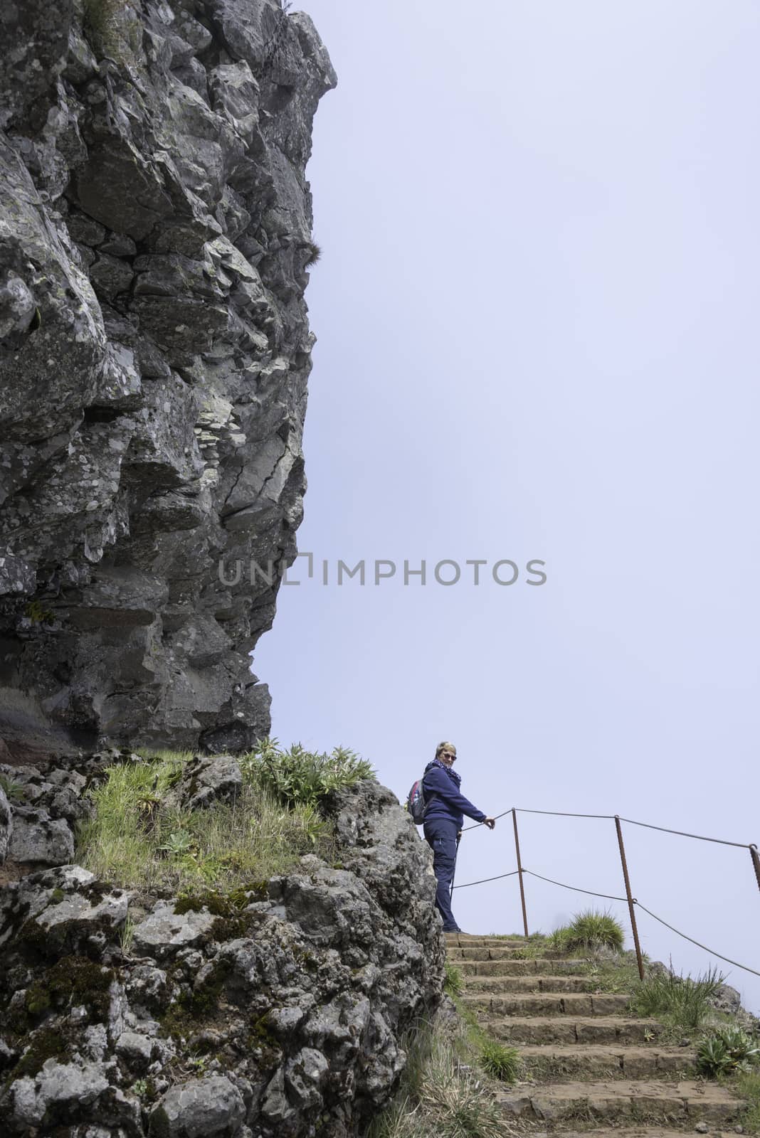 woman walking on the track at the pic arieiro, one of the highest mountains of madeira island