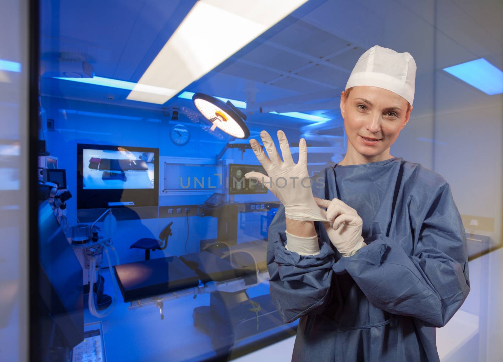 A medical personal putting protective surgeons glove in front of operating room.