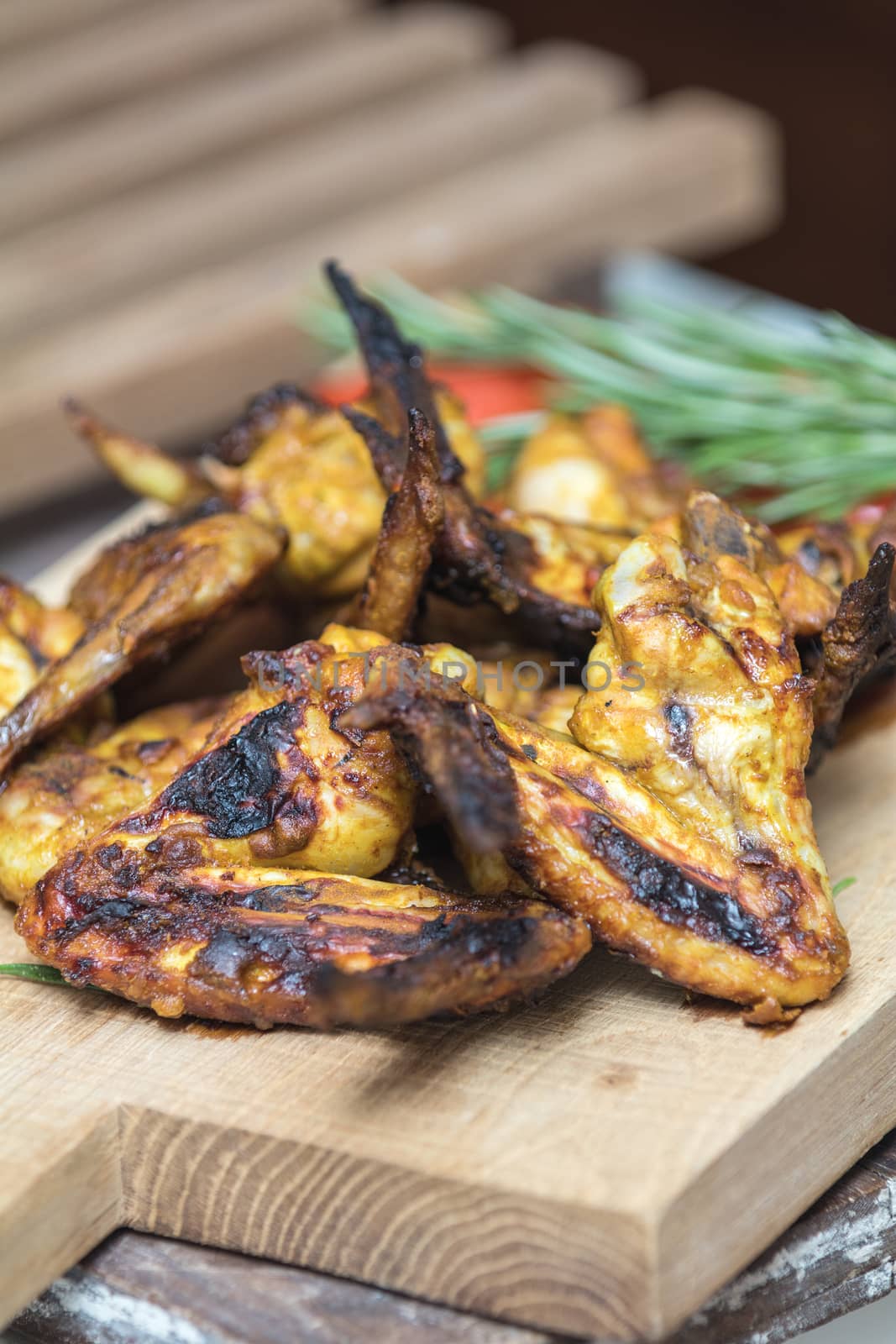 Grilled chicken wings on a light oak surface. by ArtSvitlyna