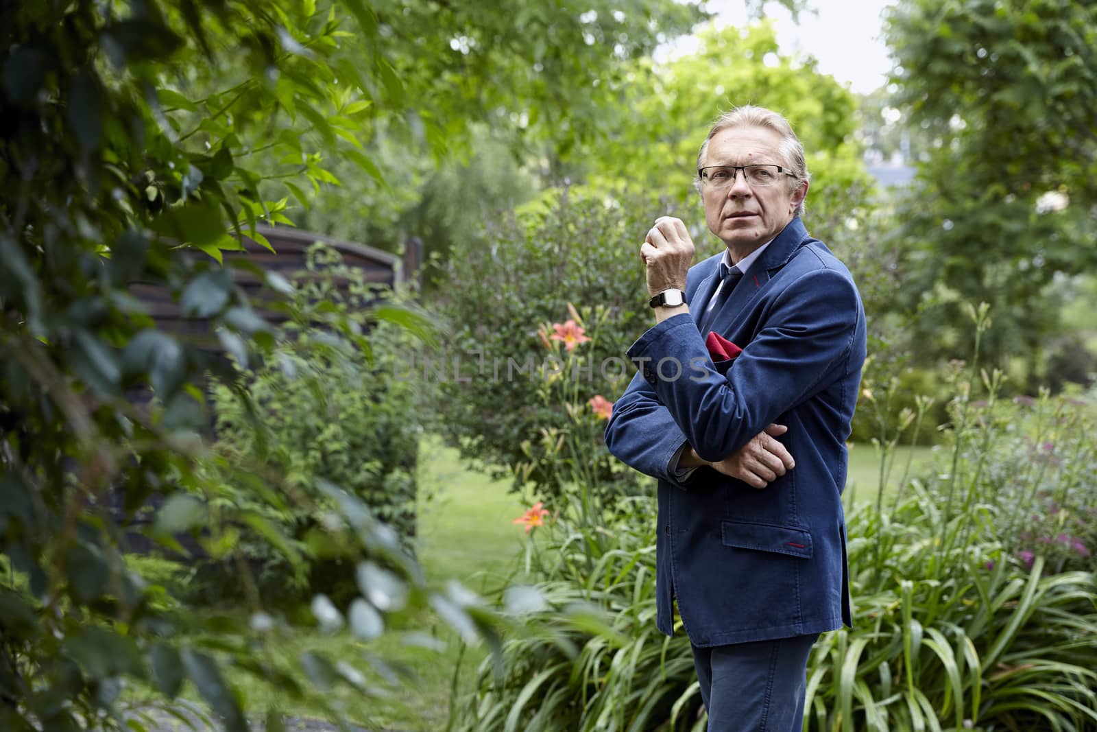 Portrait of a pensive middle-aged man in the garden. Natural sunlight.