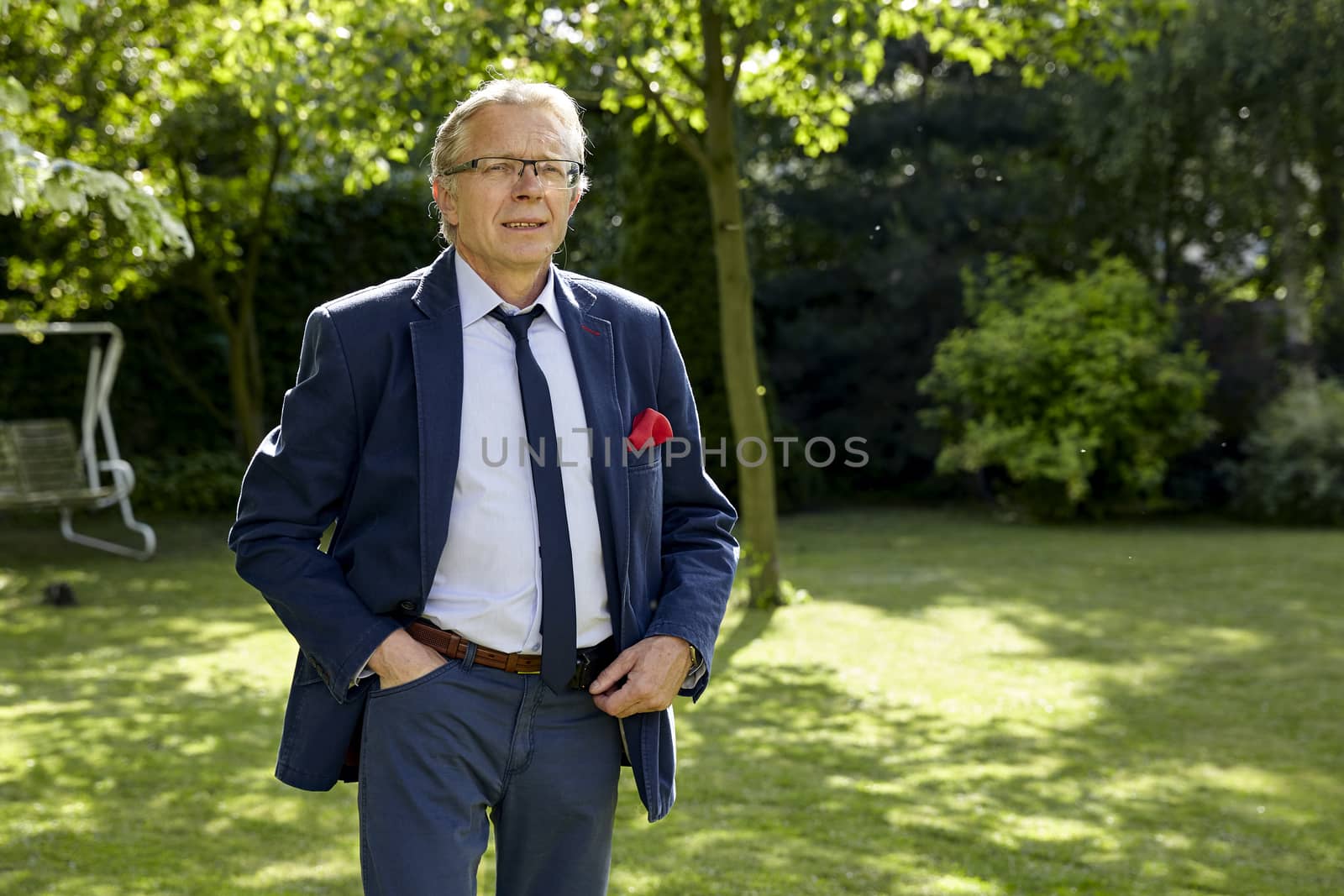 Portrait of middle-aged man in the garden at sunny day. Natural sunlight.