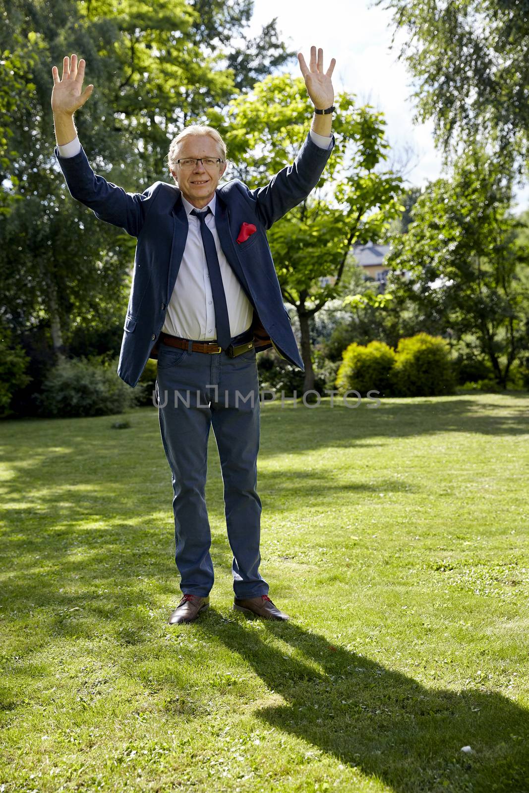 Shot of gesticulate man in the garden at sunny day. Natural sunlight.