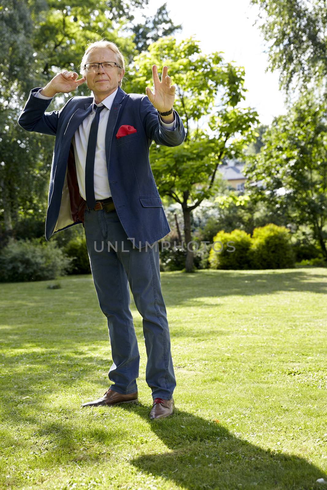 Shot of gesticulate man in the garden at sunny day. Natural sunlight.