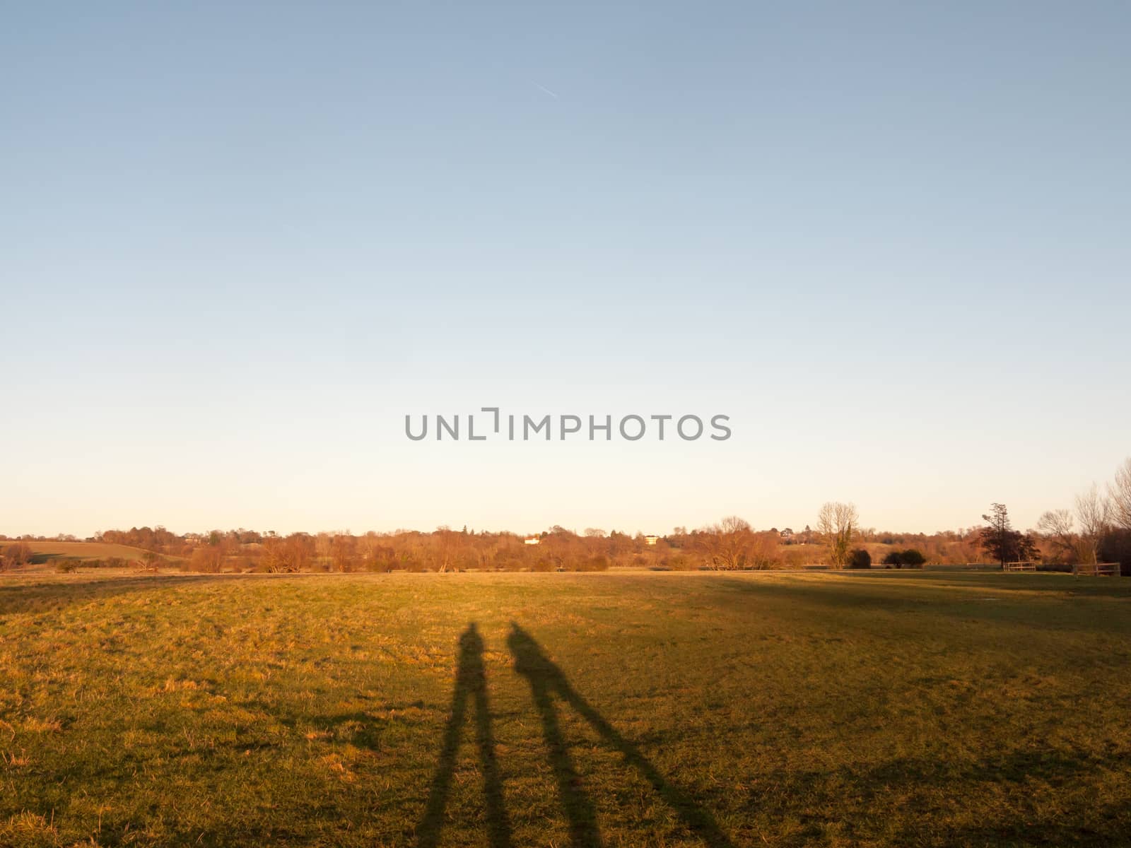 two human silhouettes large legs field of grass background; essex; england; uk