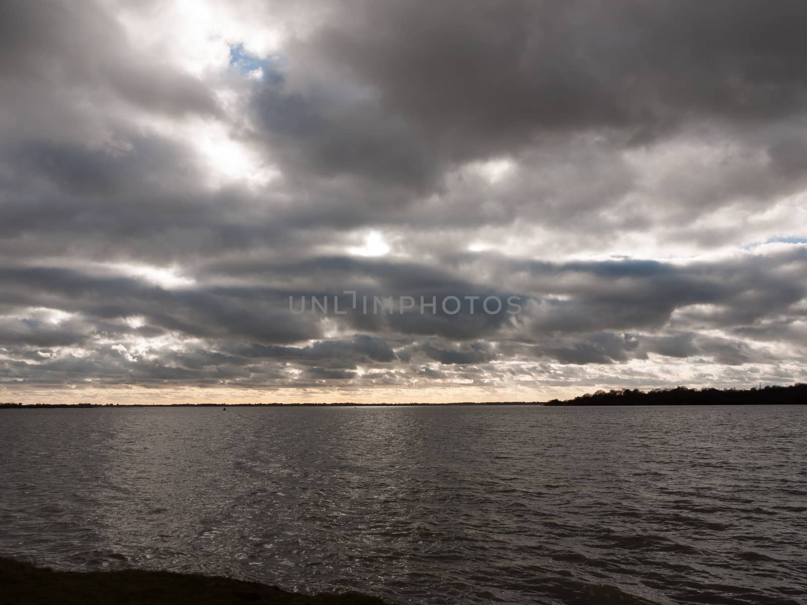 moody sky overcast autumn winter bay water ocean trees; essex; england; uk