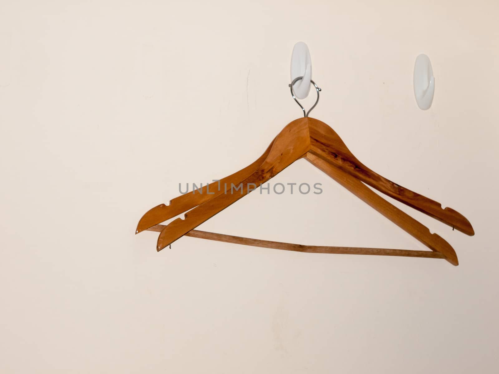 two wooden clothes hangers on white wall background empty
