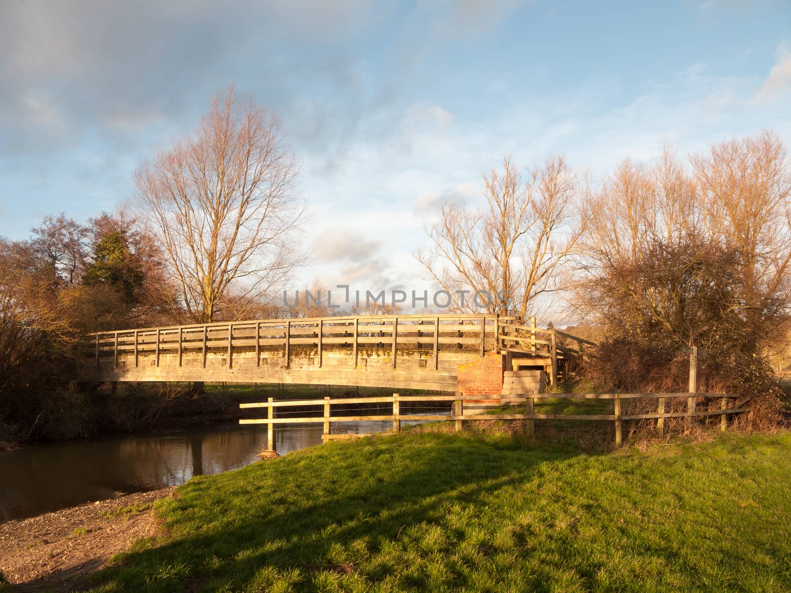 old wooden walking bridge over water sunset landscape; essex; england; uk