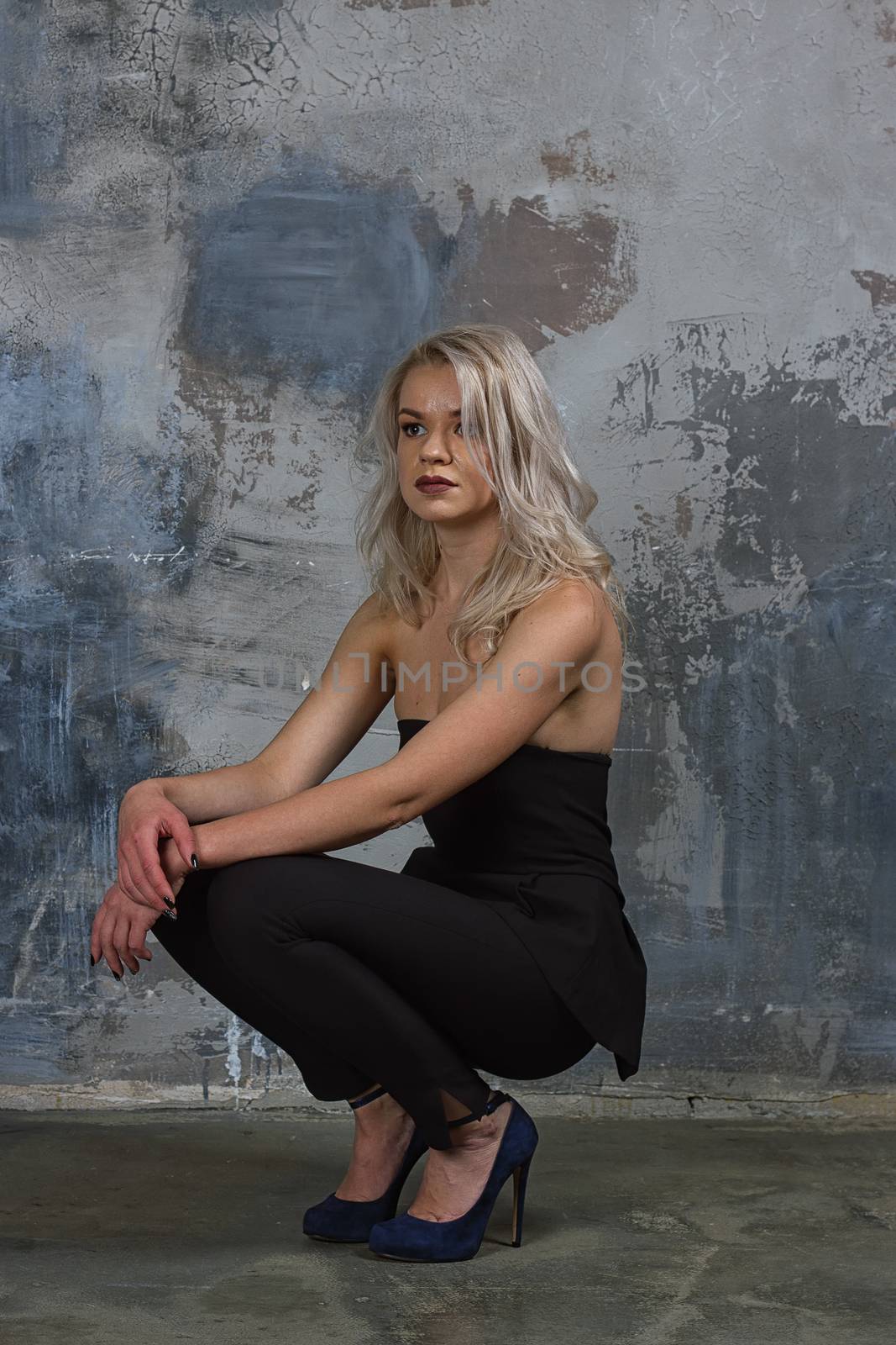 Portrait of a girl with long hair in youth clothes, Young beautiful girl near the wall her back