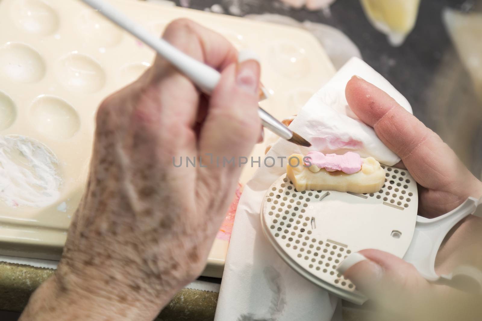 Female Dental Technician Applying Porcelain To A 3D Printed Implant Mold In The Lab.