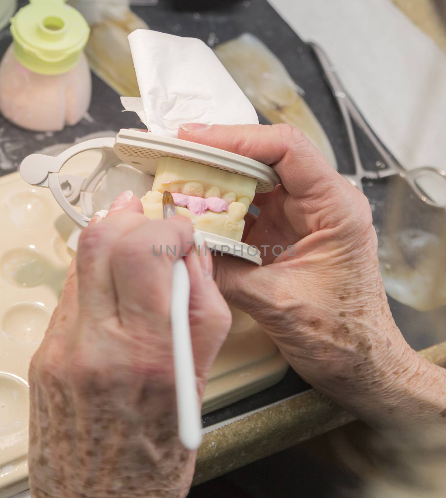 Female Dental Technician Applying Porcelain To A 3D Printed Implant Mold In The Lab.