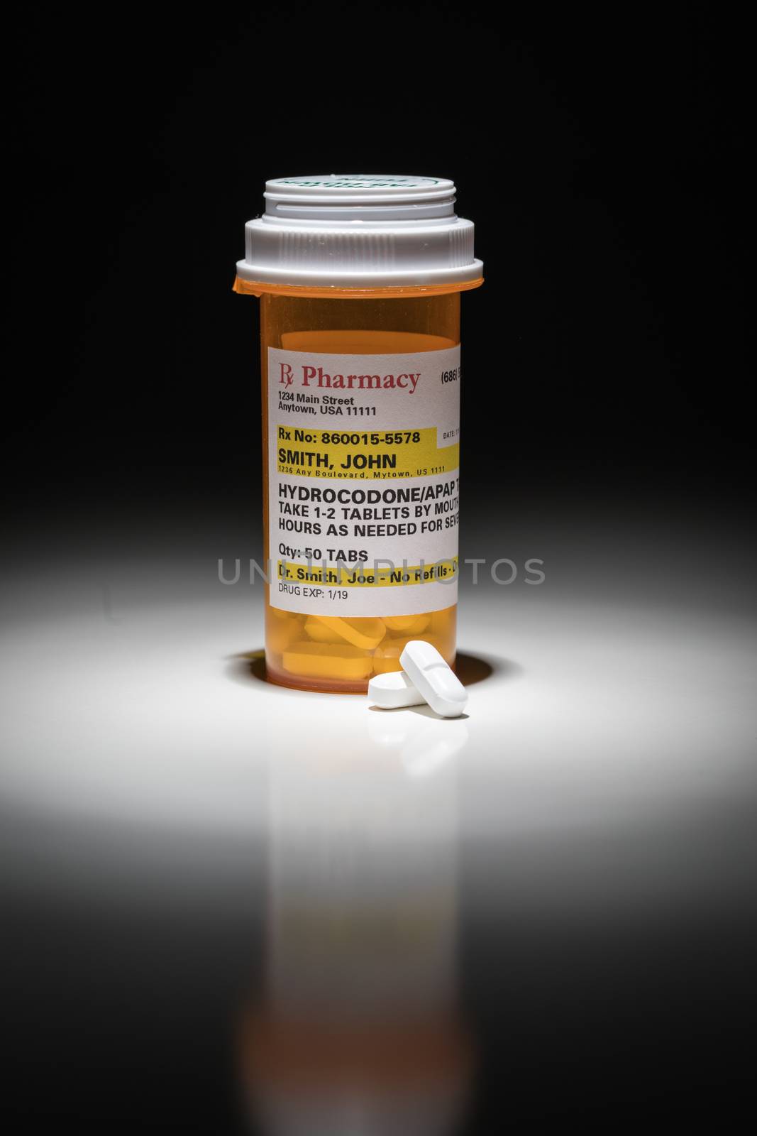 Hydrocodone Pills and Prescription Bottle with Non Proprietary Label. No model release required - contains ficticious information.