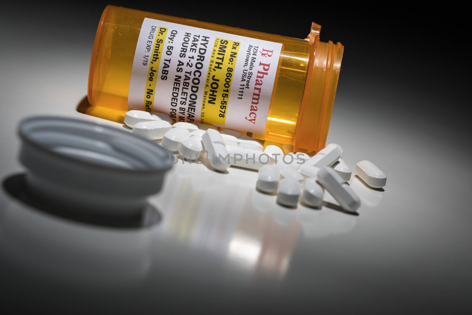 Hydrocodone Pills and Prescription Bottle with Non Proprietary Label. No model release required - contains ficticious information. by Feverpitched