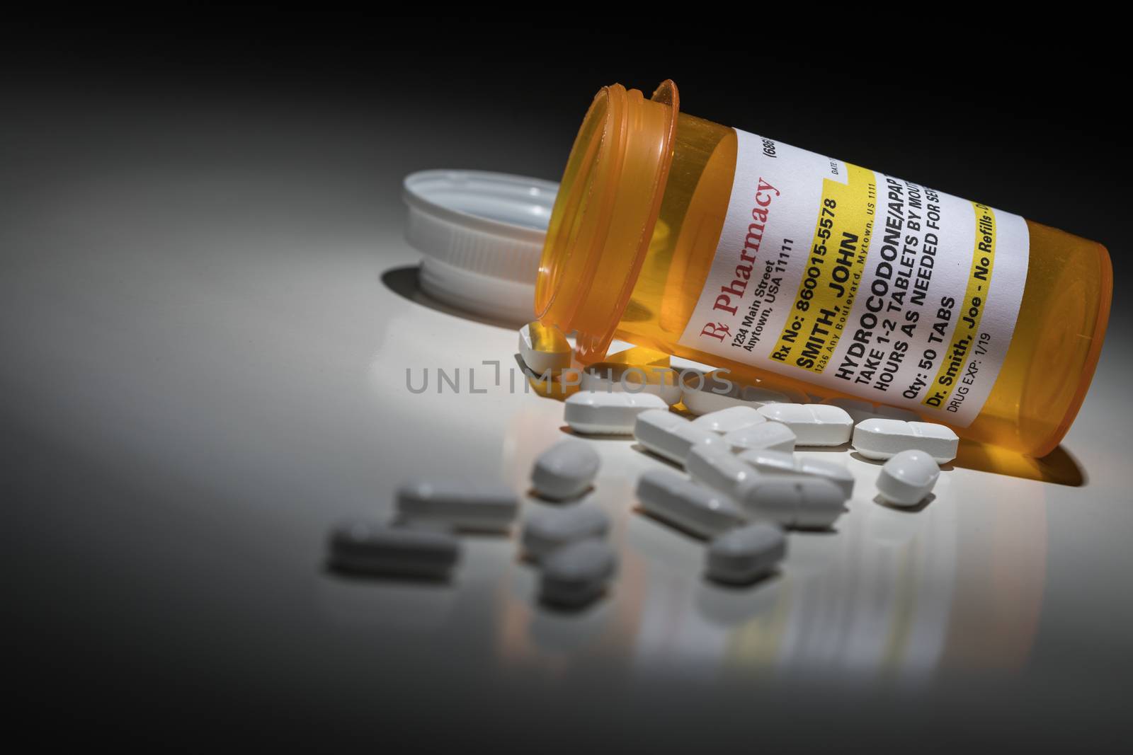 Hydrocodone Pills and Prescription Bottle with Non Proprietary Label. No model release required - contains ficticious information. by Feverpitched