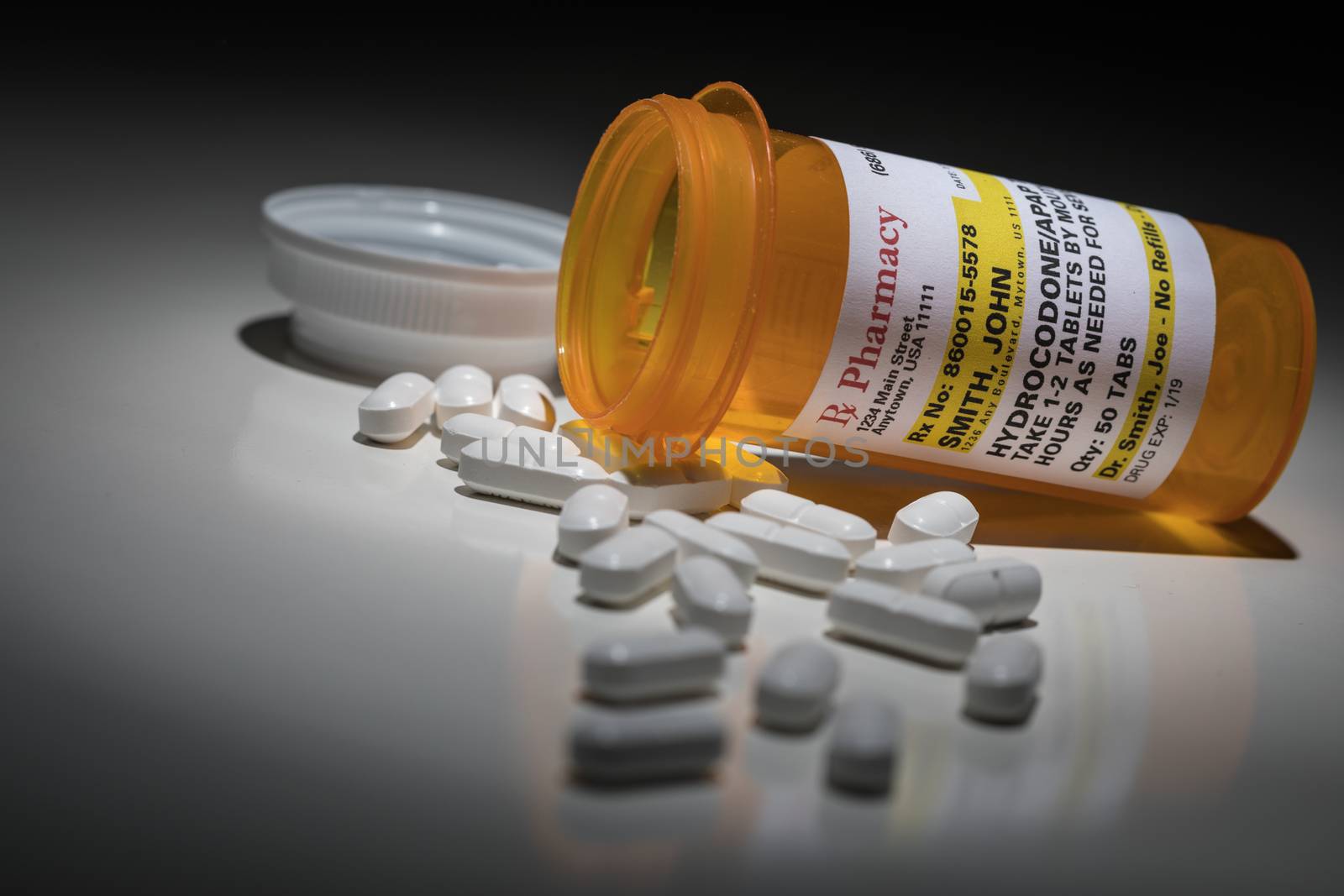 Hydrocodone Pills and Prescription Bottle with Non Proprietary Label. No model release required - contains ficticious information. by Feverpitched