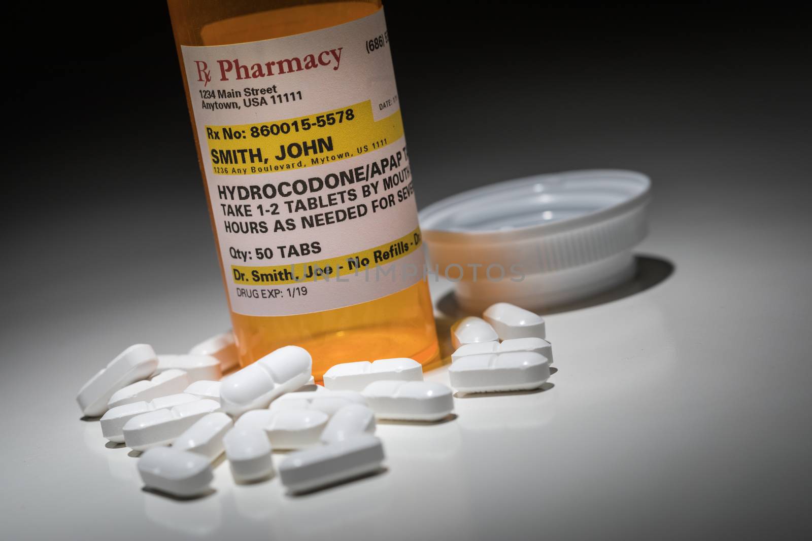 Hydrocodone Pills and Prescription Bottle with Non Proprietary Label. No model release required - contains ficticious information.