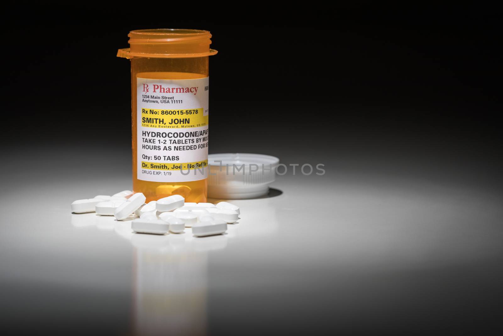 Hydrocodone Pills and Prescription Bottle with Non Proprietary Label. No model release required - contains ficticious information. by Feverpitched