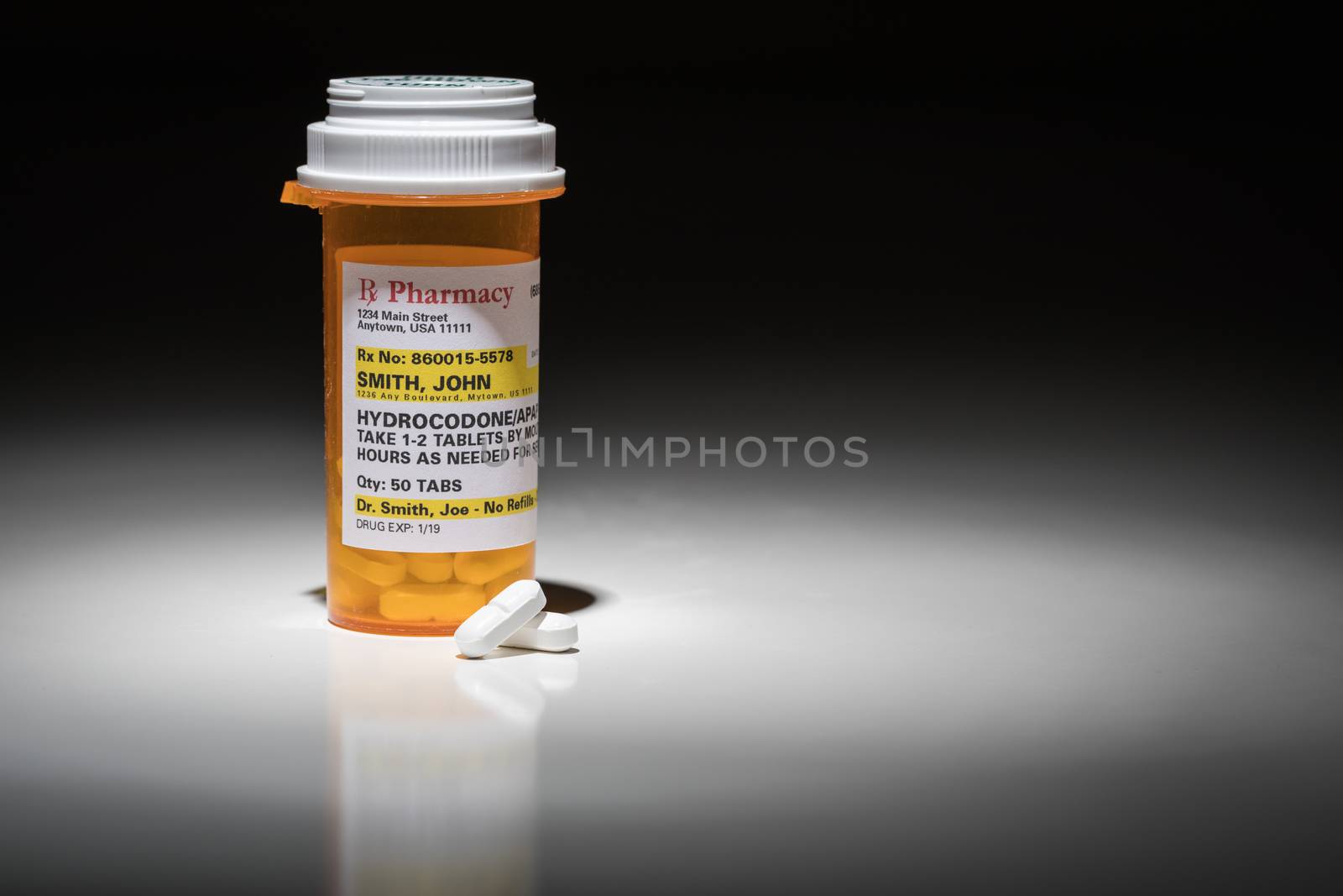 Hydrocodone Pills and Prescription Bottle with Non Proprietary Label. No model release required - contains ficticious information.