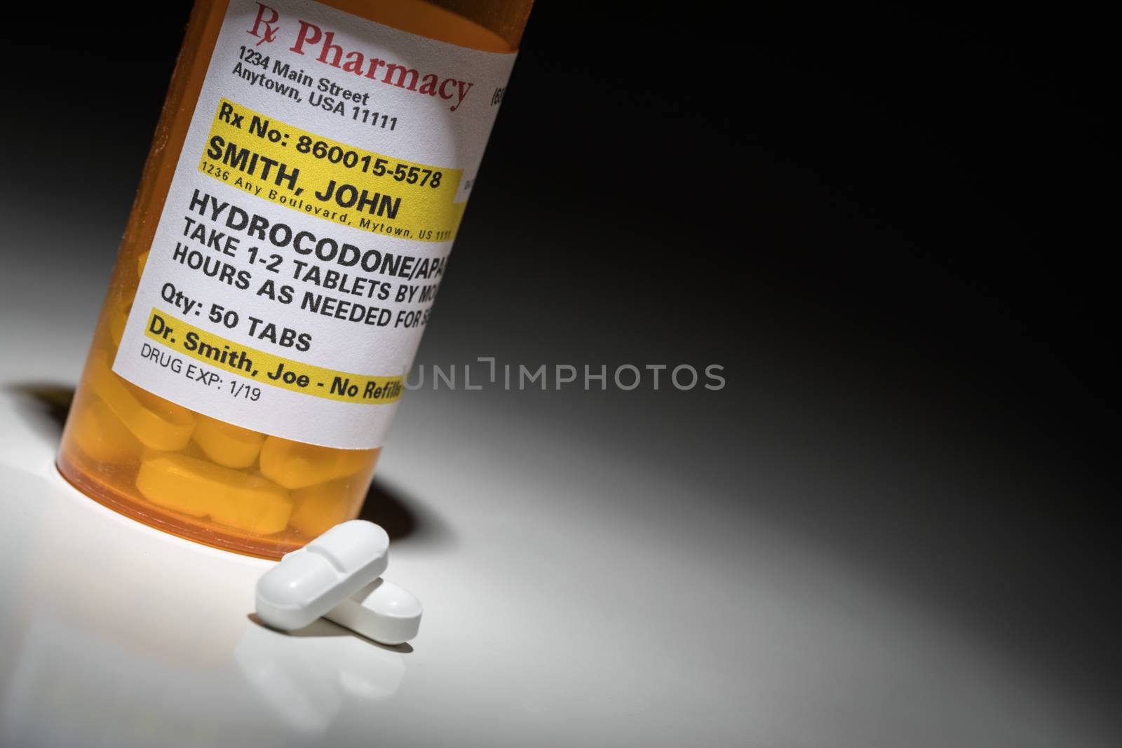 Hydrocodone Pills and Prescription Bottle with Non Proprietary Label. No model release required - contains ficticious information.