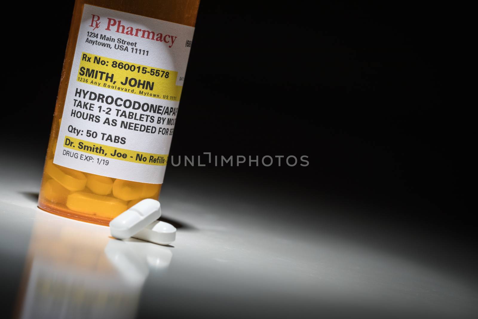 Hydrocodone Pills and Prescription Bottle with Non Proprietary Label. No model release required - contains ficticious information.