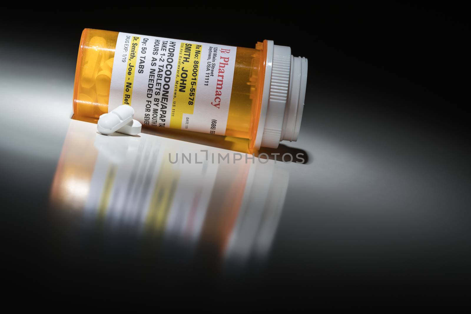 Hydrocodone Pills and Prescription Bottle with Non Proprietary Label. No model release required - contains ficticious information. by Feverpitched