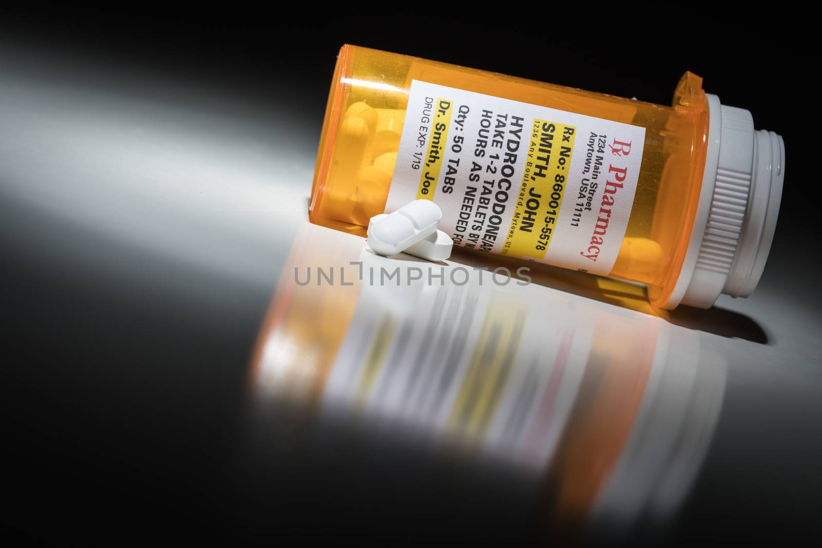 Hydrocodone Pills and Prescription Bottle with Non Proprietary Label. No model release required - contains ficticious information. by Feverpitched