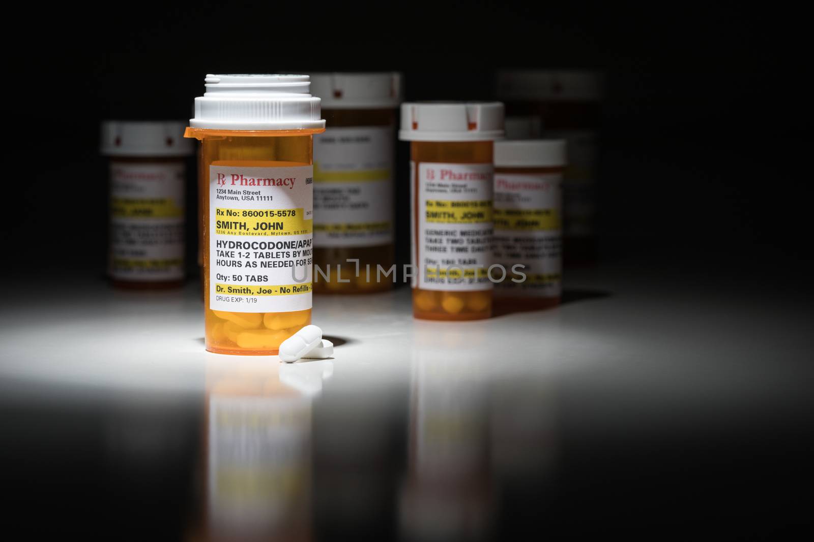 Hydrocodone Pills and Prescription Bottles with Non Proprietary Label. No model release required - contains ficticious information.