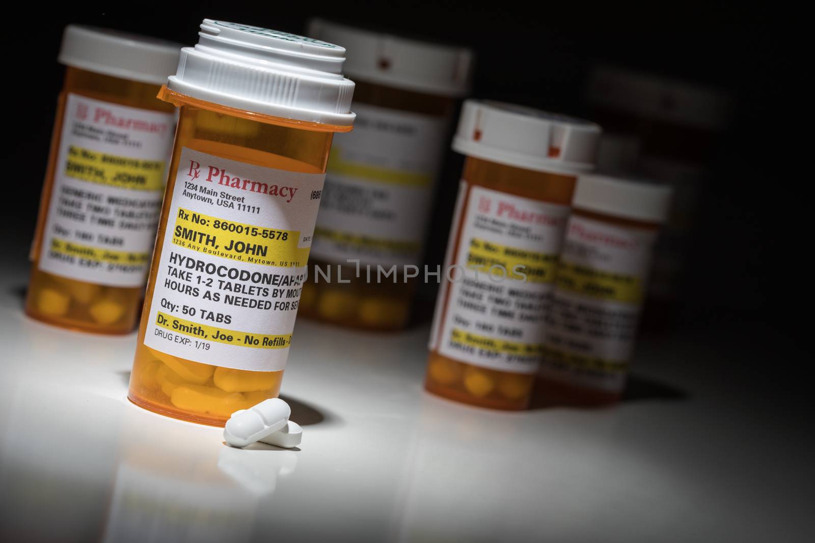 Hydrocodone Pills and Prescription Bottles with Non Proprietary Label. No model release required - contains ficticious information.