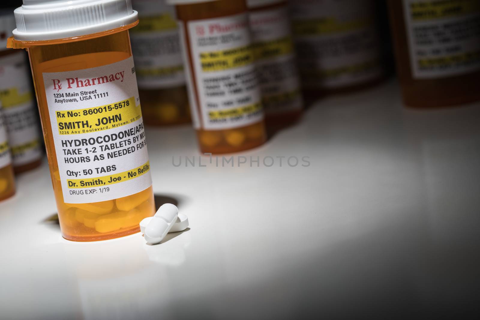 Hydrocodone Pills and Prescription Bottles with Non Proprietary Label. No model release required - contains ficticious information. by Feverpitched