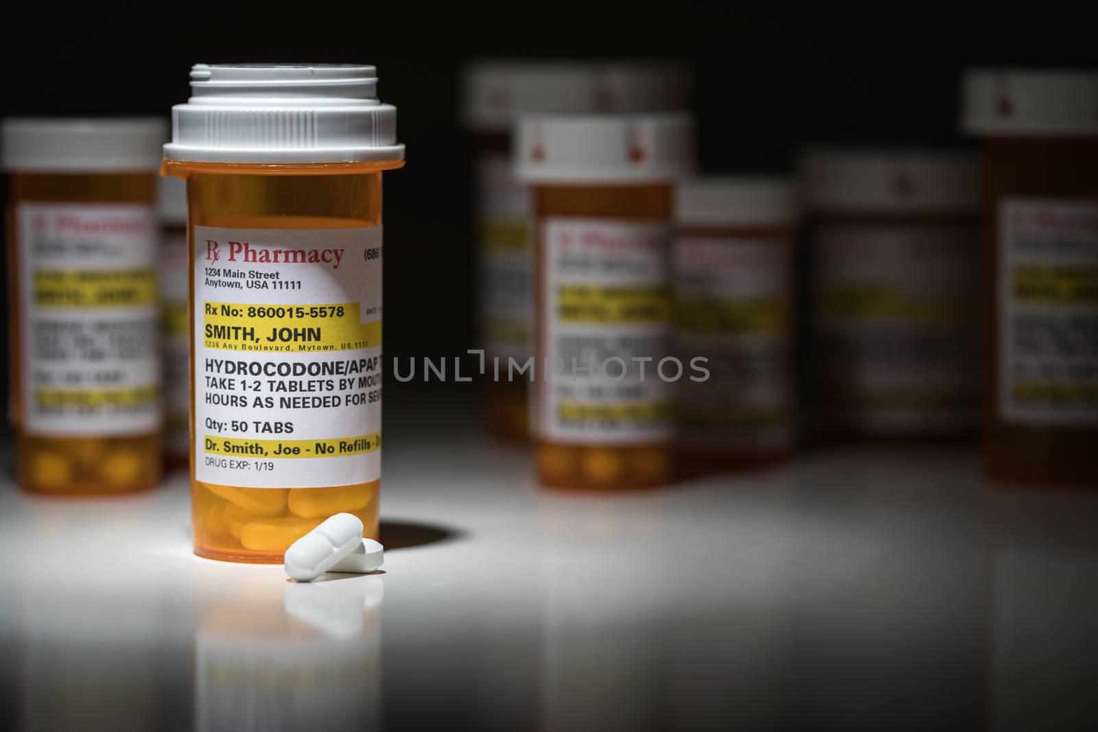 Hydrocodone Pills and Prescription Bottles with Non Proprietary Label. No model release required - contains ficticious information.