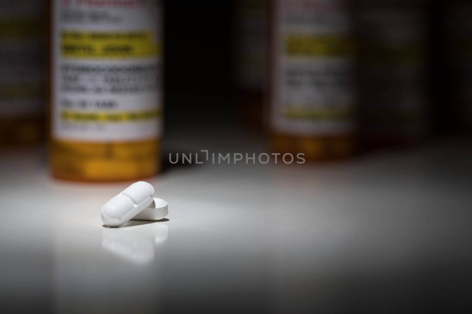 Hydrocodone Pills and Prescription Bottles Under Spot Light. by Feverpitched