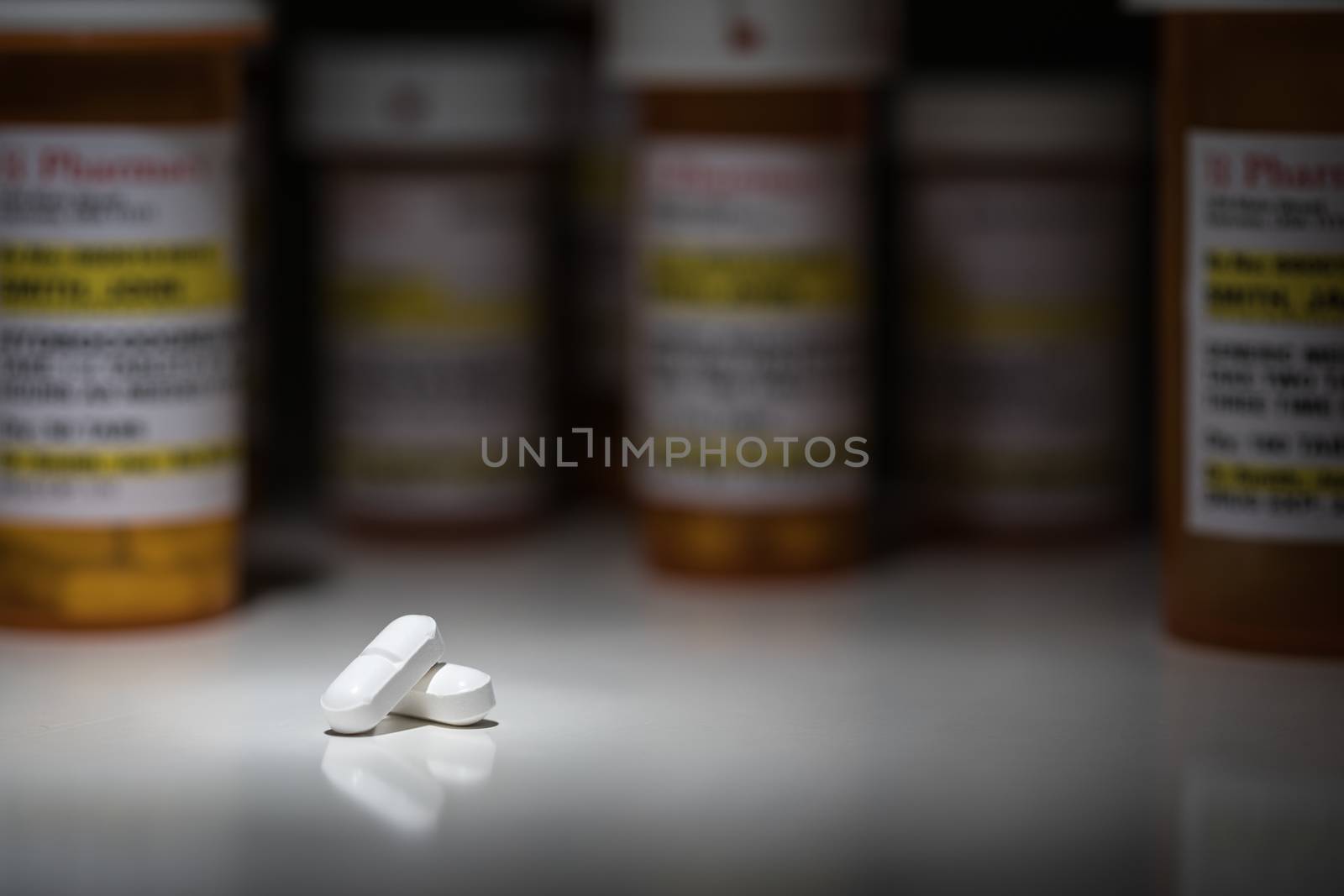 Hydrocodone Pills and Prescription Bottles Under Spot Light.