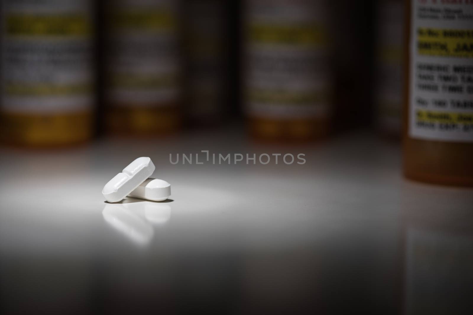 Hydrocodone Pills and Prescription Bottles Under Spot Light.