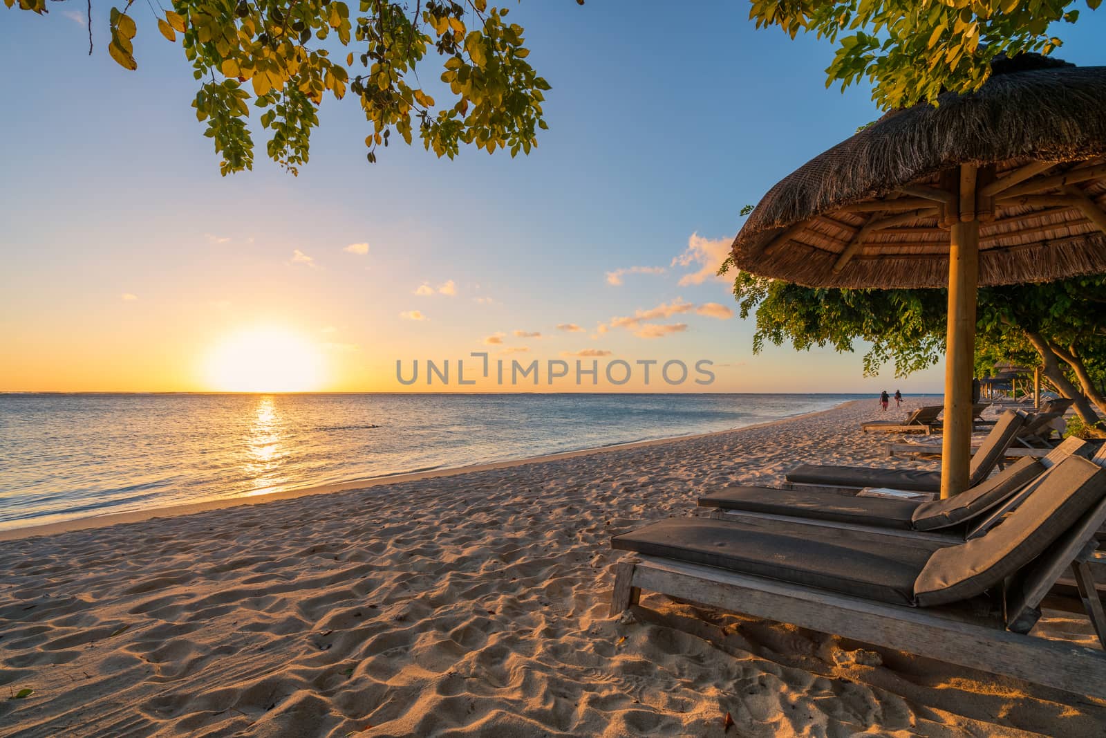 awesome beach at Mauritius island with wooden parasol in the right side, amazing sunset.