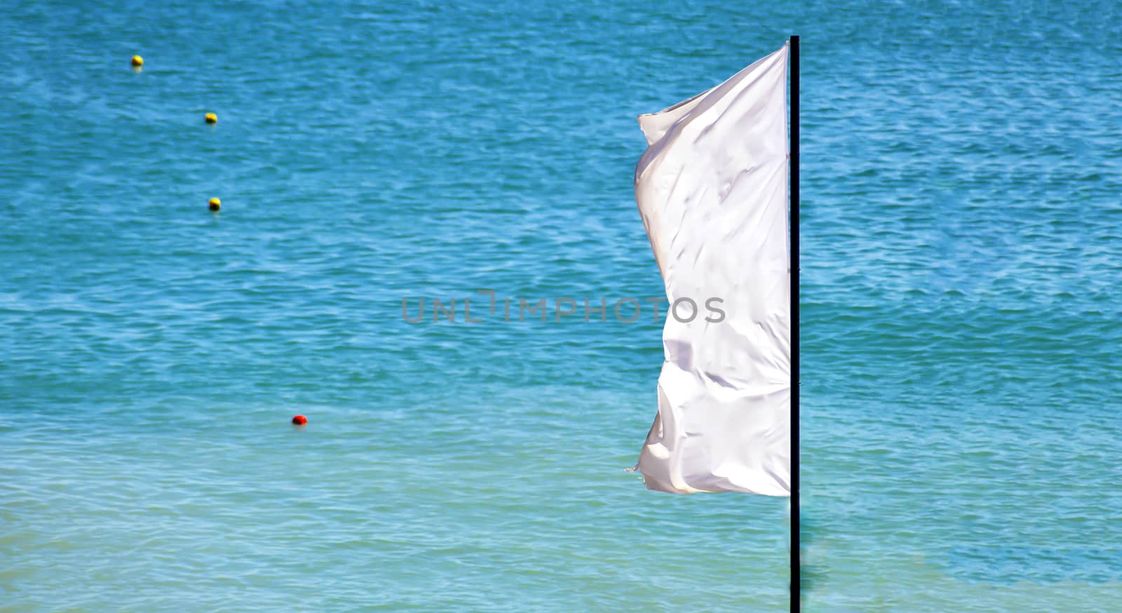 a waving white flag with a blue sea and signaling buoys in the background