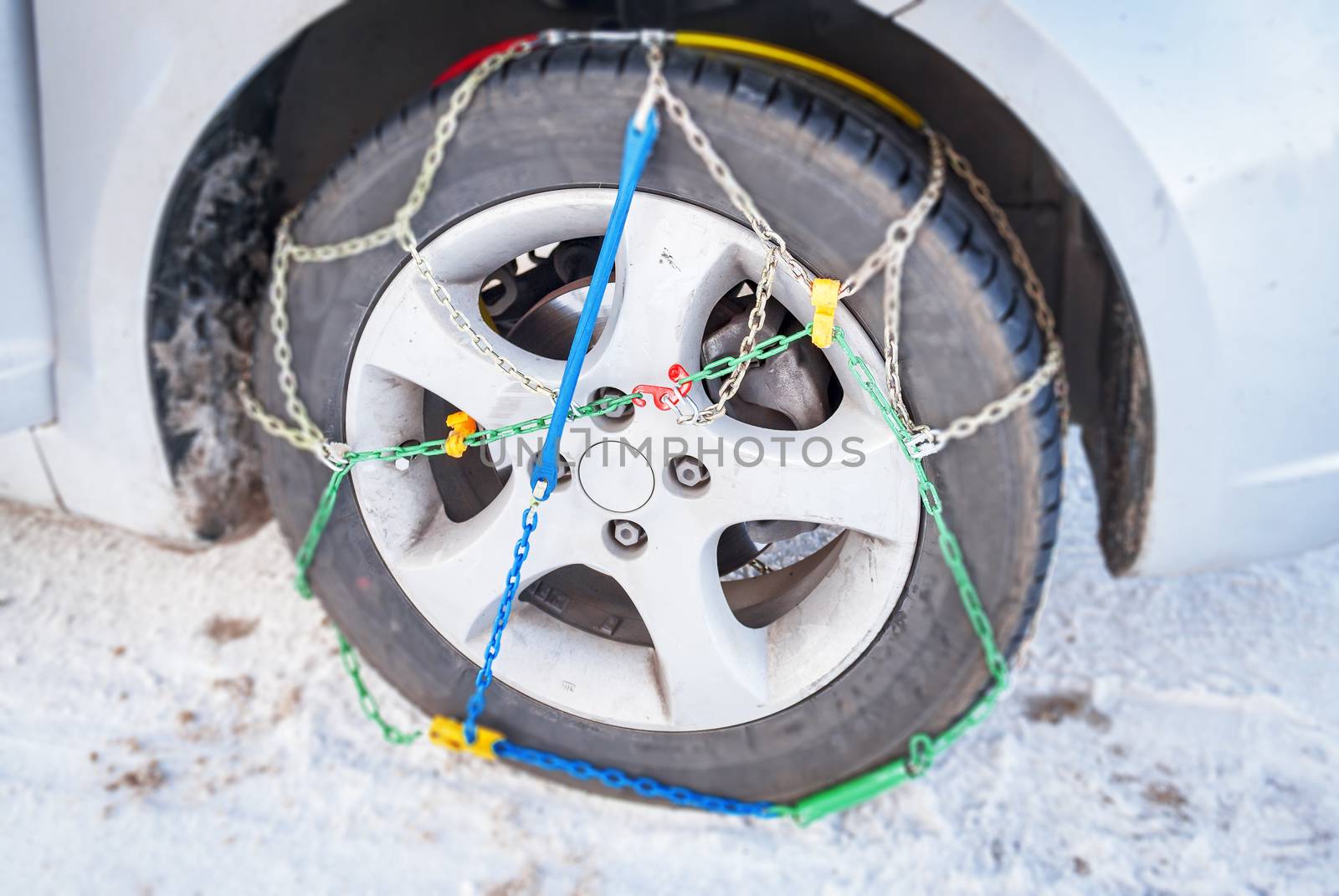 wheel of a car with mounted winter chains by rarrarorro