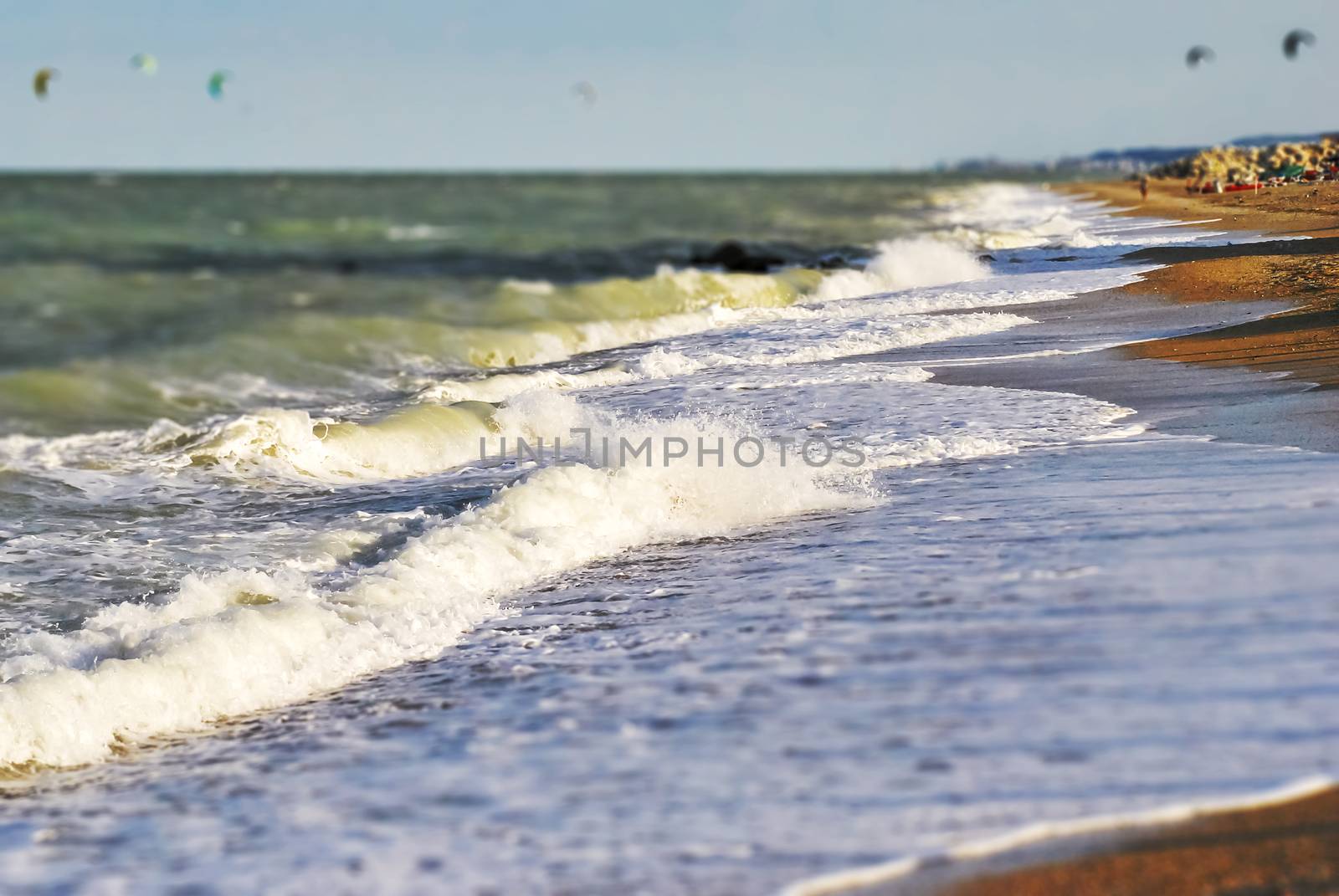 Large foamy waves crash on a beach by rarrarorro