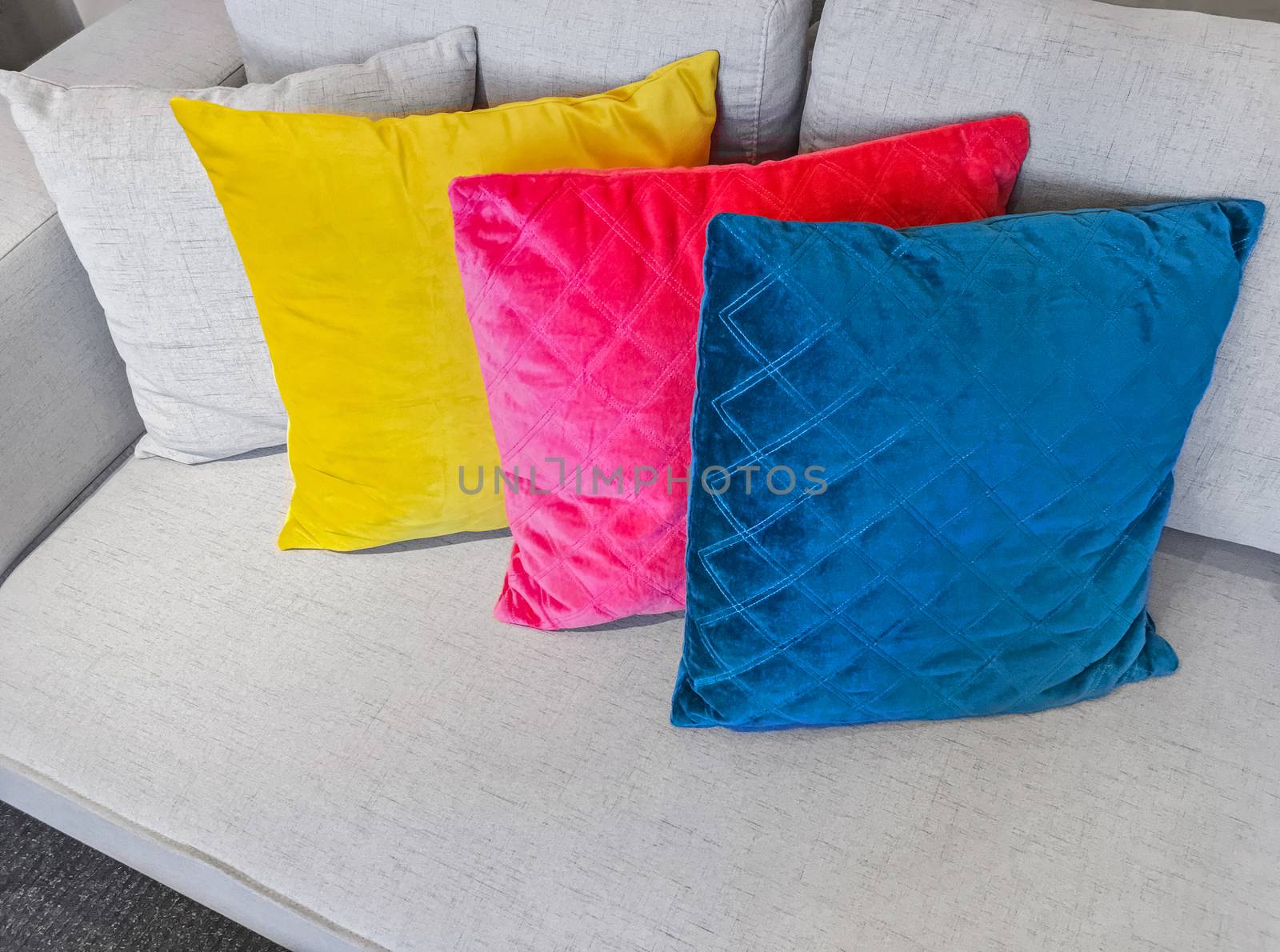 Bright multicolored cushions decorating a simple gray sofa.