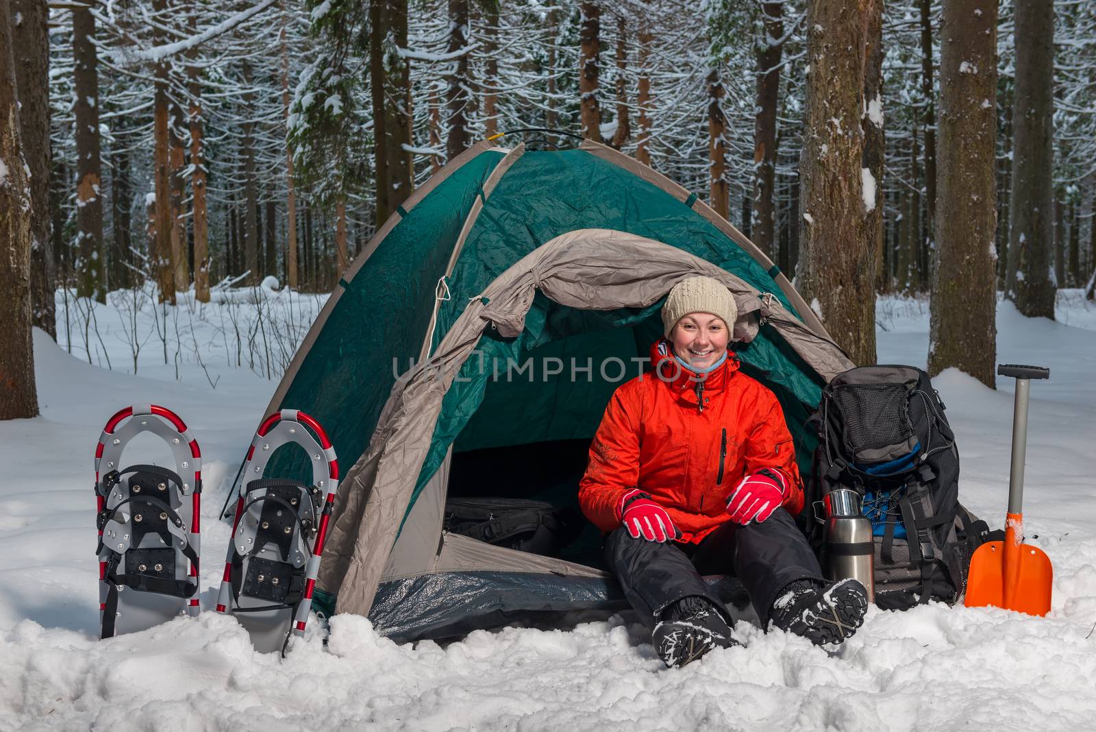 happy active tourist sits in winter forest in tent by kosmsos111