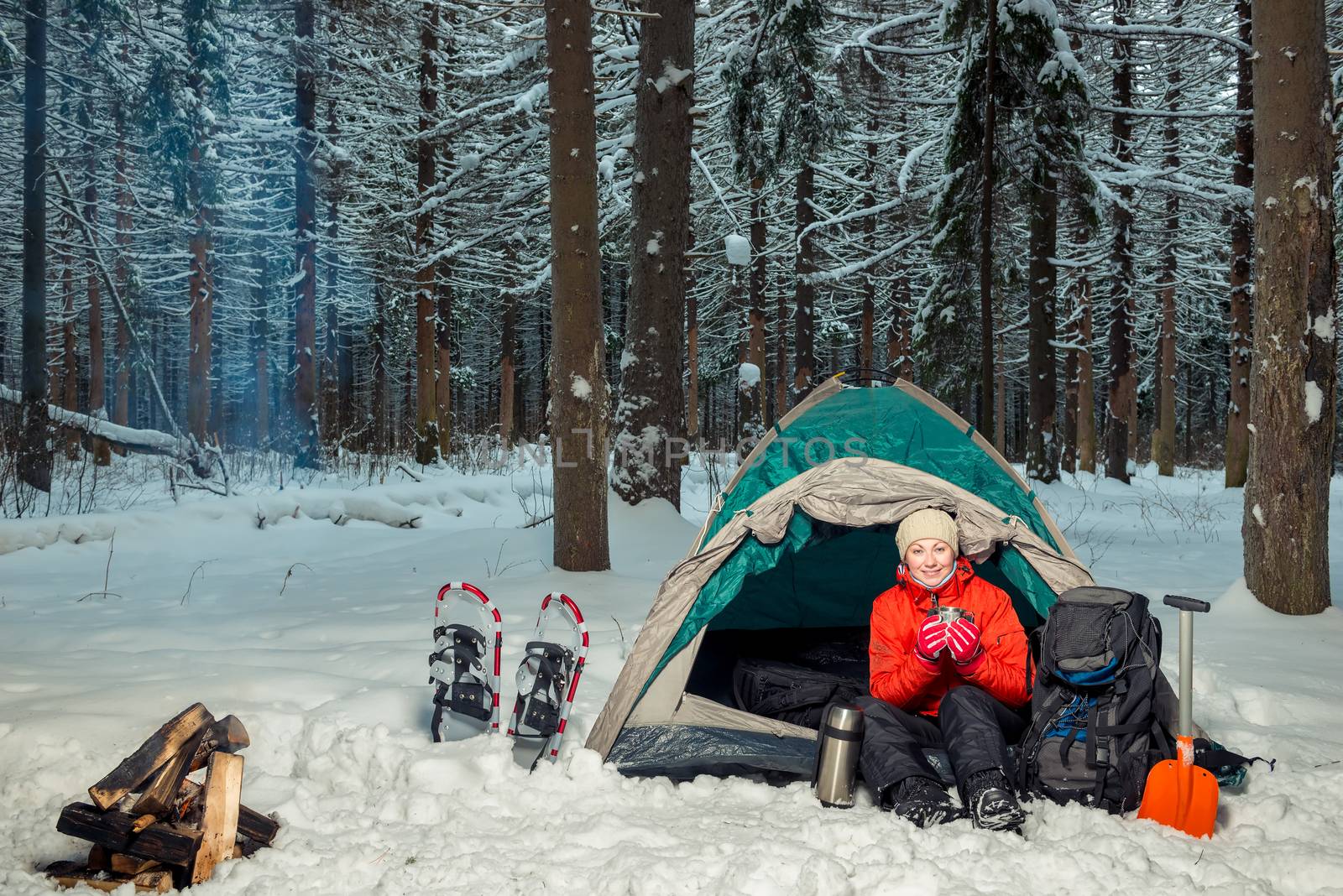 woman with hot tea in a tent in a winter forest by kosmsos111