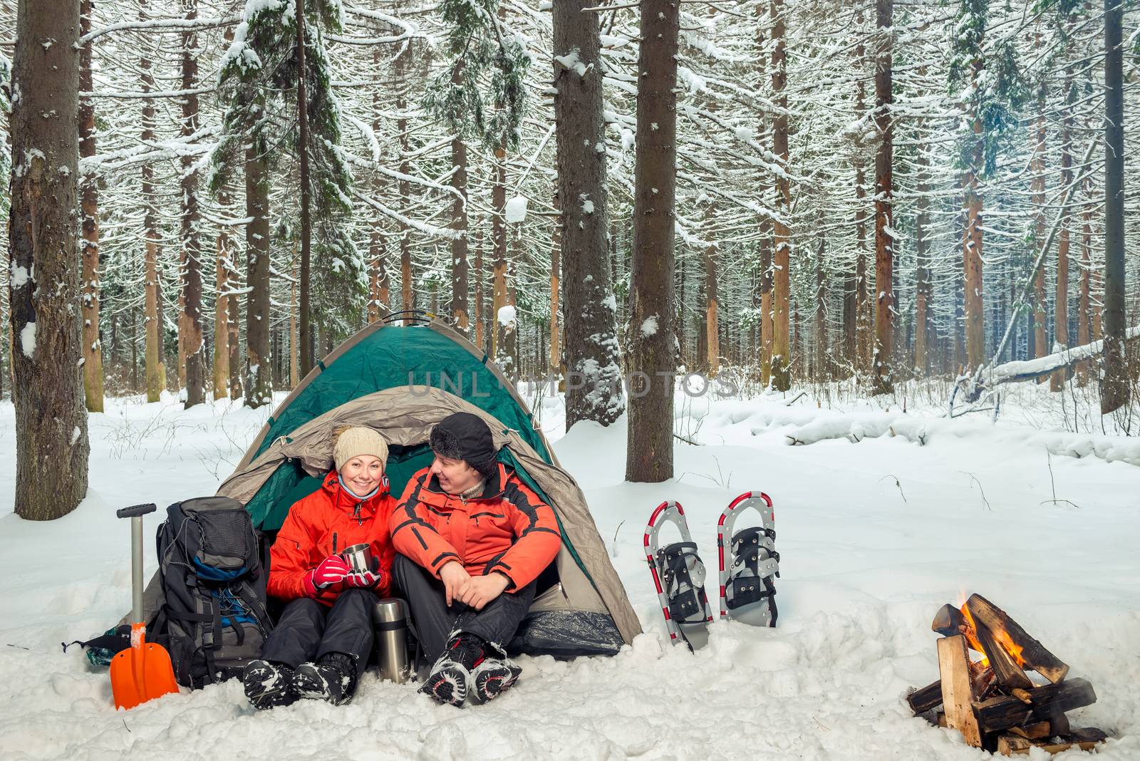 man and woman active tourists, campground in the winter forest