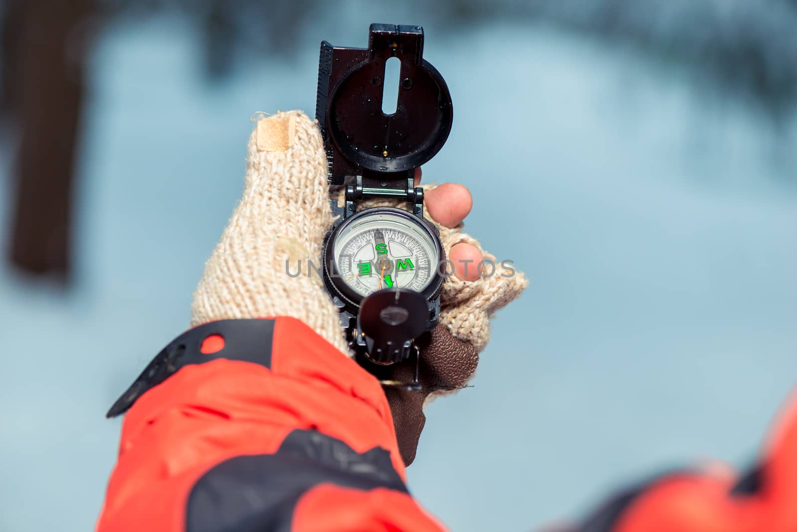 close-up of a compass in the hand of a lost tourist in a winter forest