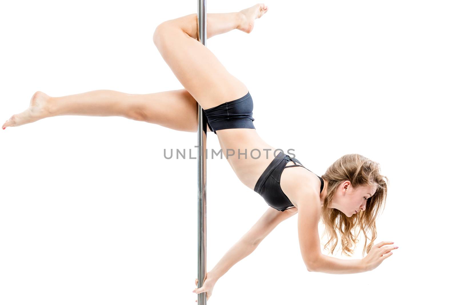 beautiful slender girl upside down on a pylon performs sports items on a white background