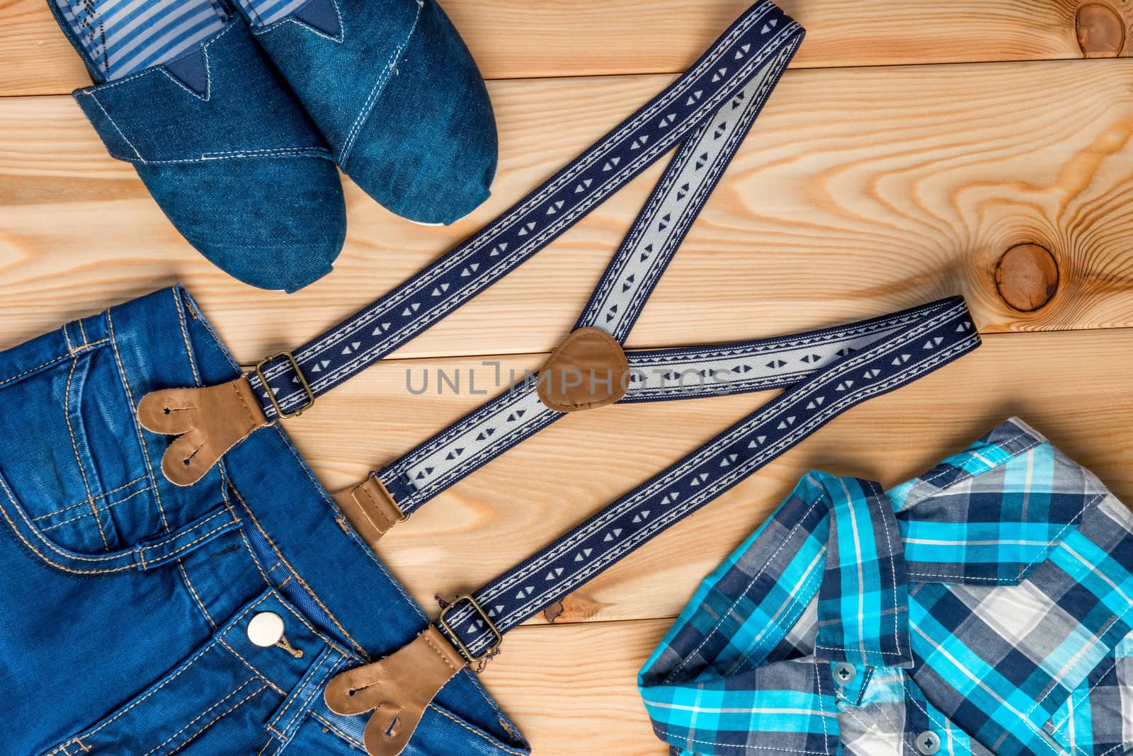 set of clothes in a rural style top view on a wooden floor for a boy